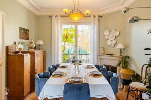 a dining room with a table and blue chairs at luxury Villa Marie Emeraude Paris Orly Jacuzzi in Draveil