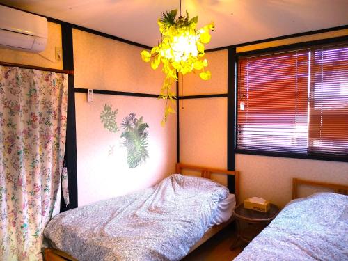 a bedroom with a bed and a chandelier at シーカレント　ゆな　CHIKURA in Chikura