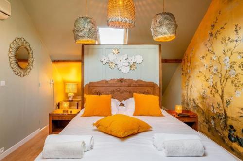 a bedroom with a large bed with yellow pillows at luxury Villa Marie Emeraude Paris Orly Jacuzzi in Draveil