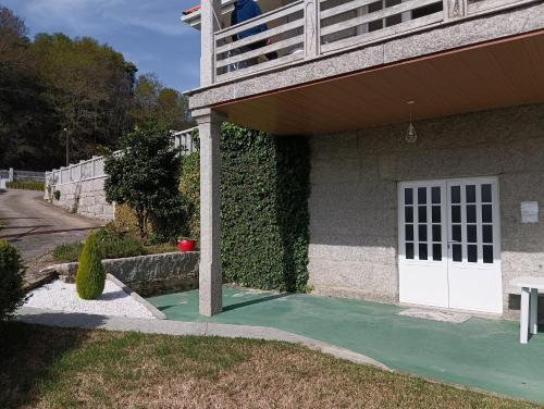 Casa con puerta blanca y balcón en La Favorita, en Pontevedra