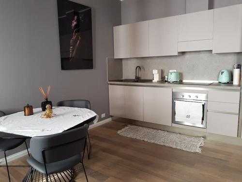 uma cozinha com uma mesa e uma cozinha com armários brancos em Still und Stilvoll im Stadtzentrum em Trieste