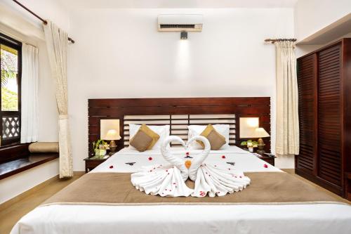 a bedroom with a large bed with a swan decoration on it at Greenwoods Resort, Thekkady in Thekkady