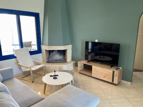 a living room with a couch and a tv and a fireplace at Amalfi Complex in Kato Almiri