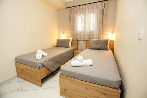 2 camas en una habitación pequeña con ventana en Amaryllis Seaview House by GuestCorfu, en Corfú
