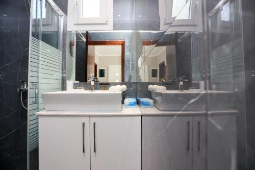 a bathroom with two sinks and a mirror at Amaryllis Seaview House by GuestCorfu in Corfu