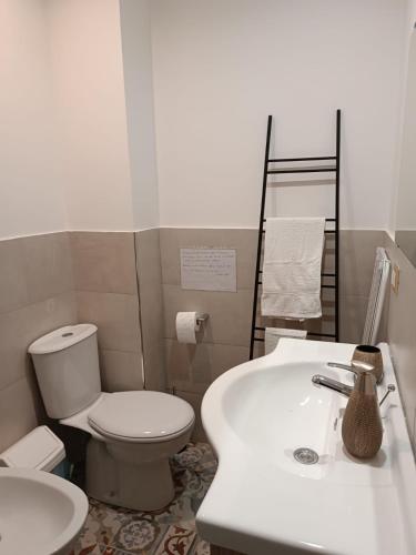 a white bathroom with a toilet and a sink at I VACANZIERI in Avola