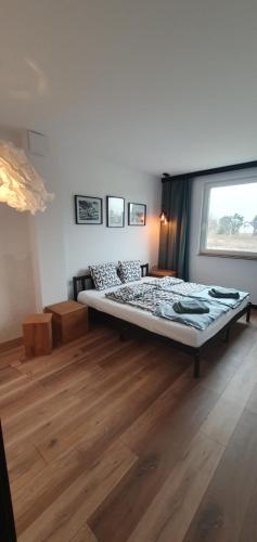 een slaapkamer met een groot bed en een raam bij Apartament przy jeziorze w Pszczewie in Pszczew