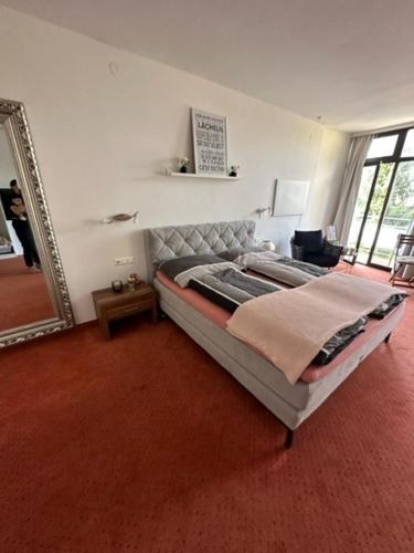 a bedroom with a bed and a mirror in it at Pension COLUMBIA inkl. Frühstück im Zentraum in Bad Gleichenberg