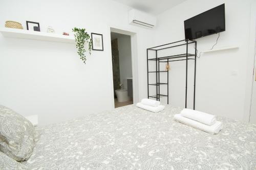 a white room with a table and a tv on a wall at Los Alonsos - Open Mall - By AZ Rentals in Arrecife