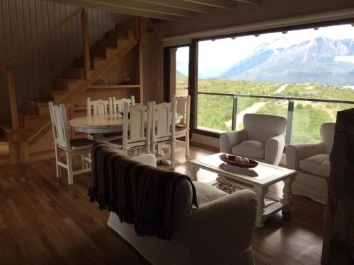 sala de estar con mesa, sillas y ventana grande en Terrazas del Pol en San Carlos de Bariloche