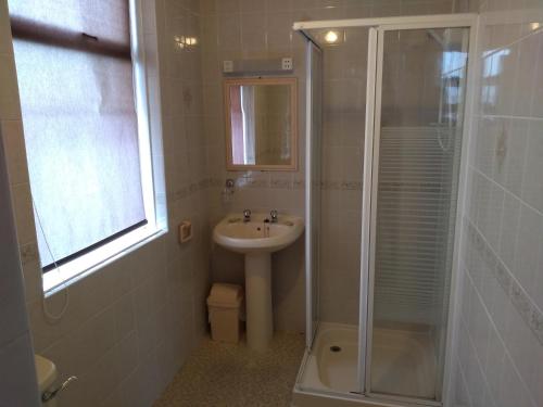 a white bathroom with a sink and a shower at Southview Hotel in Blackpool
