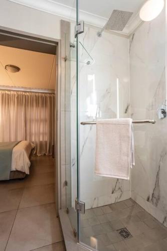 a bathroom with a shower with a glass door at Fore's Luxurious Home in Midrand