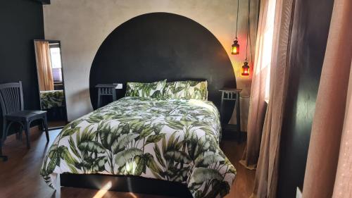ein Schlafzimmer mit einem Bett mit einer Blattdecke in der Unterkunft La Black Casa in Zafra