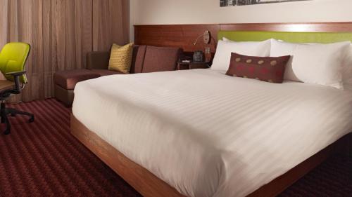 a large white bed in a hotel room at Tŷ Magor in Magor