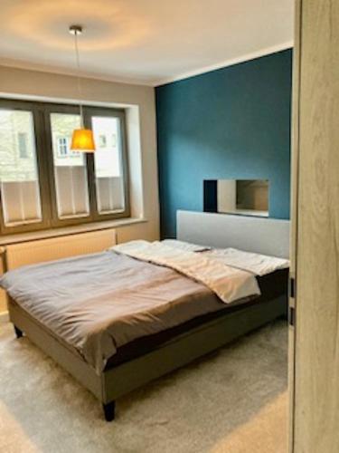 1 dormitorio con 1 cama con pared azul en Ferienhaus Stadtmauer, en Lichtenfels