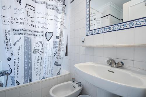 y baño con lavabo, aseo y espejo. en Hostal Alicia, en Marbella