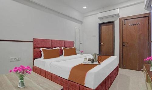 a bedroom with a large bed with a red headboard at FabHotel Elite Residency in Indore