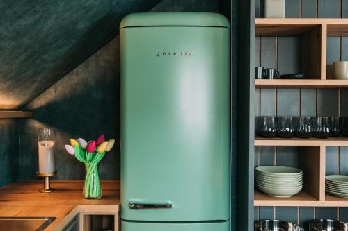 a green refrigerator in a kitchen next to a shelf at Guest House Pohorska Kavarna in Maribor