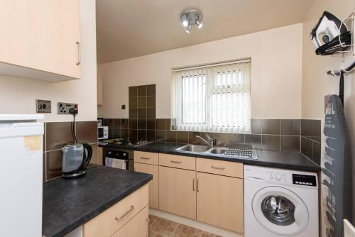 a kitchen with a washing machine and a sink at Barden Moor in Darlington