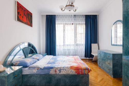 a bedroom with a bed and blue curtains at Bright 2-BD Top Central Apartment in Sofia