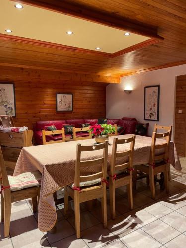 une salle à manger avec une table, des chaises et un canapé dans l'établissement CHALET HOLIDAY, aux Gets