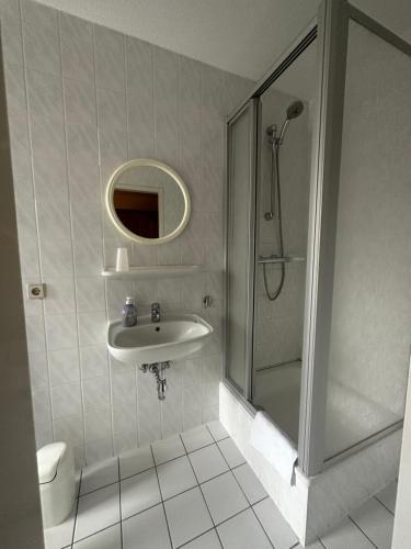 uma casa de banho com um lavatório, um chuveiro e um WC. em Pension Zum Erzgebirge em Kurort Altenberg
