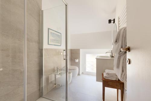 y baño con ducha, aseo y lavamanos. en Spiga 46 Suites by Brera Apartments, en Milán