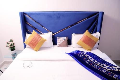 uma cama com cabeceira azul e almofadas em Fortune Home Service Apartment 1bhk, D-198,UGF em Nova Deli