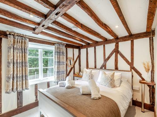 a bedroom with a bed in a room with wooden ceilings at The Cottage in Broomfield