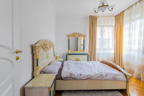 een slaapkamer met een bed, een dressoir en een raam bij Bright 2-BD Top Central Apartment in Sofia