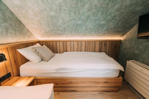 a small bedroom with a bed in a room at Guest House Pohorska Kavarna in Maribor