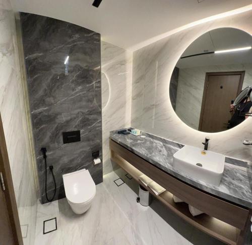 La salle de bains est pourvue d'un lavabo, de toilettes et d'un miroir. dans l'établissement MD Hotel By Gewan, à Dubaï