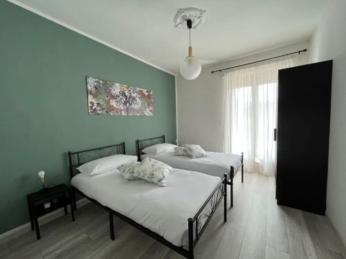 2 Betten in einem Zimmer mit grünen Wänden in der Unterkunft La Casa Di Sabi in Locana