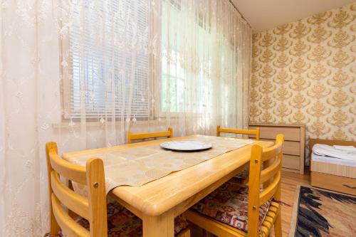 een eetkamer met een houten tafel en stoelen bij 1-Bedroom Flat with Balcony in Plovdiv in Plovdiv
