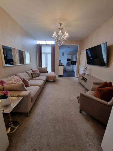 een woonkamer met banken en een flatscreen-tv bij Lovely home close to MCR centre inc Cinema in Manchester