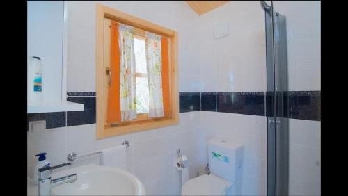 a bathroom with a toilet and a sink and a window at Equestrian and Beach Club in Bodrum City