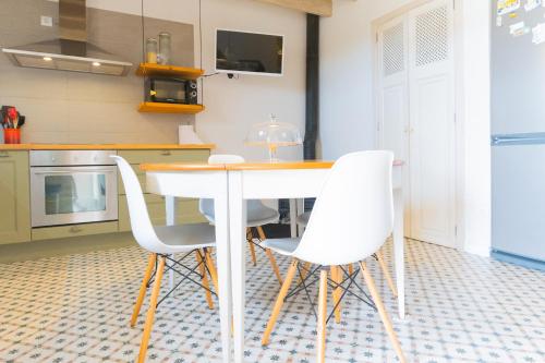 a kitchen with a white table and white chairs at Pintor - Rustic Mallorquin town house 3 bedrooms and pool in Caimari in Caimari