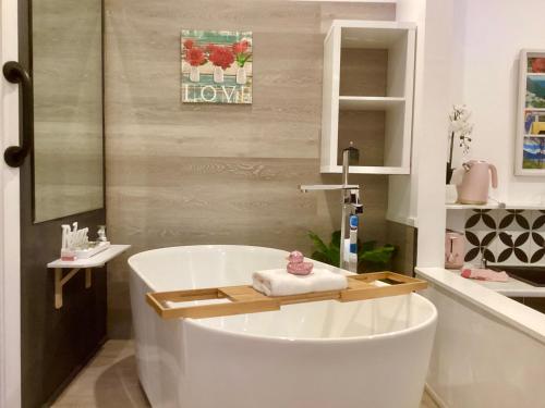 a bathroom with a white tub and a sink at Chalet Relax on Gallery Walk with Bath, Fireplace, WiFi & Netflix in Mount Tamborine