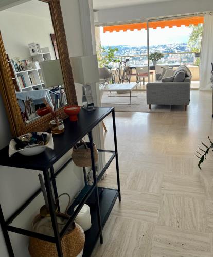 - un salon avec une table et un miroir dans l'établissement Au calme, dans la verdure, vue panoramique sur Cannes, au Cannet
