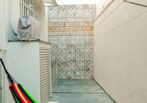 a hallway with a tile wall and a refrigerator at Terreo 3qtos,6camas,3tvs in Cabo Frio