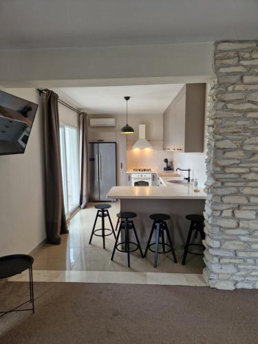 a kitchen with a table and chairs and a stone wall at Villa Olivetum in Marina
