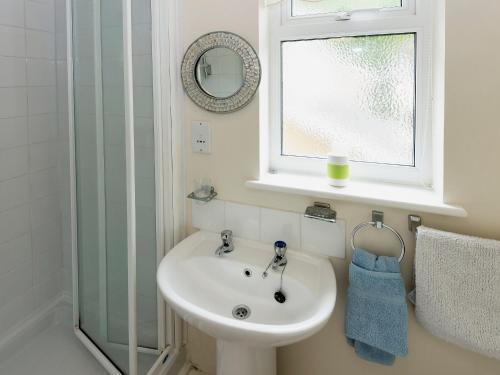a bathroom with a sink and a window and a mirror at Hydan Creek Gardens in Wootton Bridge