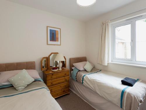 a bedroom with two beds and a window at Hydan Creek Gardens in Wootton Bridge