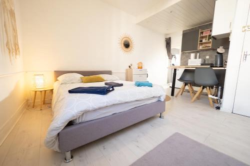 a bedroom with a bed with white sheets and a desk at La Chouette de la Cathédrale - Calme - Jardin - Wifi in Troyes