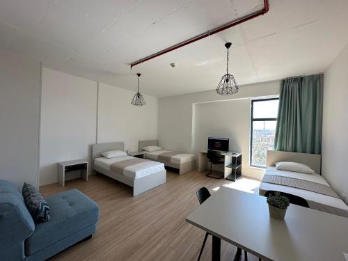 - un salon avec un canapé, un lit et une table dans l'établissement ApartHotel Folé, à Tirana