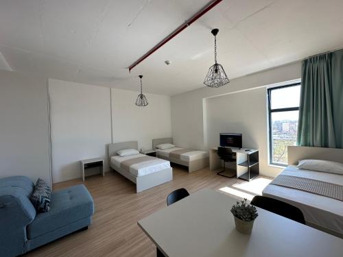 uma sala de estar com duas camas e um sofá em ApartHotel Folé em Tirana