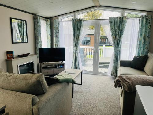 a living room with a couch and a sliding glass door at Evergreen Lodge with Hot Tub in York