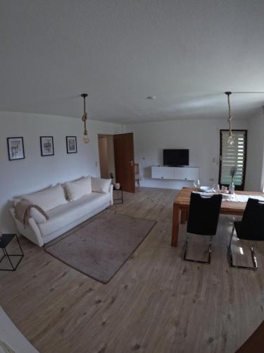 a living room with a white couch and a table at J&J Apartment in Wutöschingen
