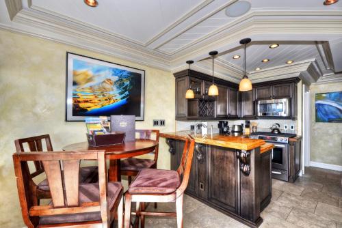 a kitchen with a wooden table and a kitchen island at Villa Bella Mare at the Retreat in Laguna Beach in Laguna Beach