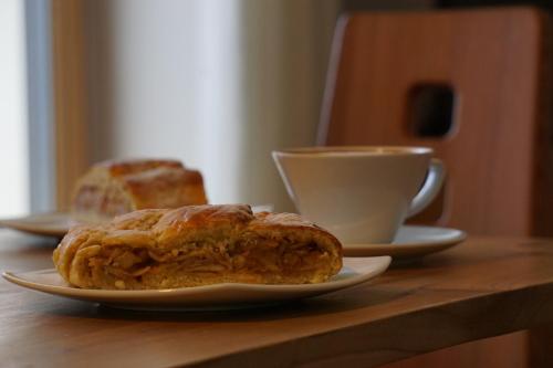 a table with two pastries and a cup of coffee at Waalhof Ferienwohnung Apfelblüte in Silandro